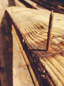 A rusty nail sticking out of some reclaimed lumber