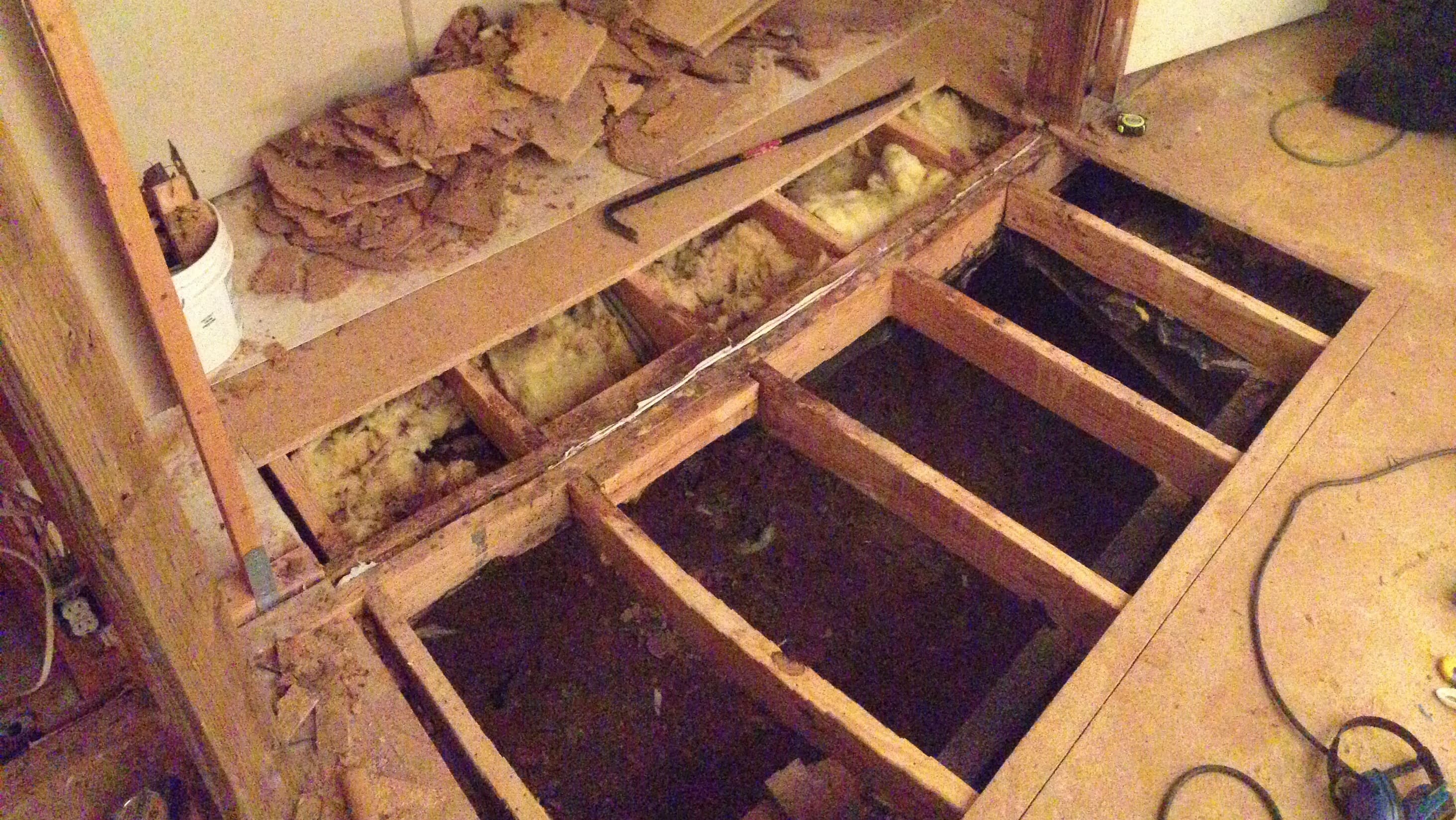 an image looking down into a large hole in the floor of our homestead. it is being repaired