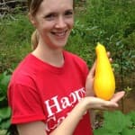 Jenn holds her first yellow squash harvested from our homestead